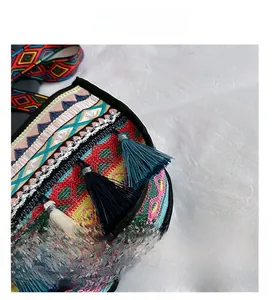 Close-up of ethnic style woven bag with colorful geometric jacquard and fringe details