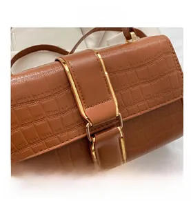 Close-up of brown crocodile pattern leather with premium golden metal clasp detail