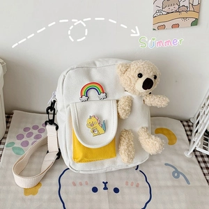 Sac bandoulière en toile blanche avec poche jaune, ours en peluche et motifs arc-en-ciel