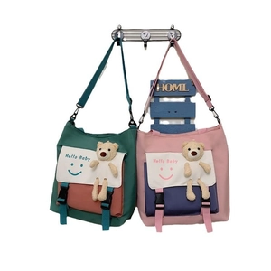 Contrast stitching canvas tote bag with smiley face print and plush bear charm decoration