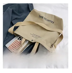 Detail view of khaki canvas tote bag showing spacious interior and magnetic snap closure