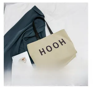 Vue détaillée du grand sac cabas en toile montrant sa capacité pour iPad et objets divers