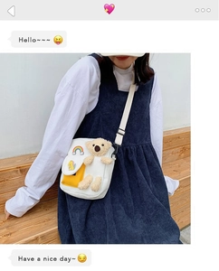 Vue détaillée du sac bandoulière en toile blanche avec ours en peluche et poche jaune