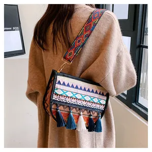 Detail of bohemian woven crossbody bag with colorful embroidery and tassel fringe