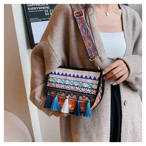 Close-up of bohemian crossbody bag with colorful geometric embroidery and stylish fringe