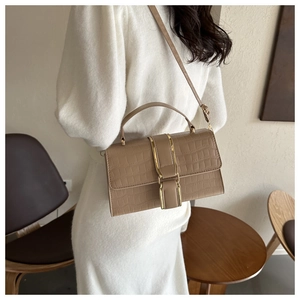 Detail of khaki crocodile pattern crossbody bag with gold metal handle and long strap