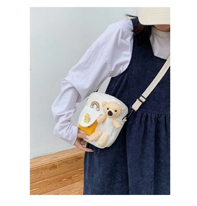 Détail du sac bandoulière en toile avec ours en peluche, arc-en-ciel et badge