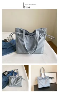 Detalle del bolso tote azul grande de nailon con cierre de cordón y correas de hombro