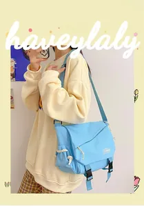 Detail view of light blue canvas messenger bag with flap closure and buckle