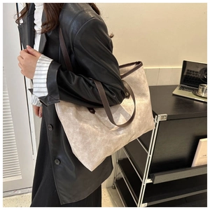 Detailed view of the large bucket tote bag featuring textured faux leather and brown handles