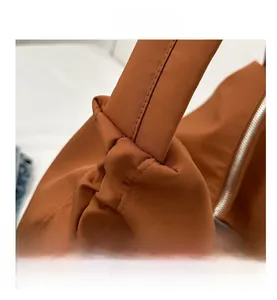 Gros plan sur le nœud et les coutures du sac cabas en nylon marron avec fermeture éclair