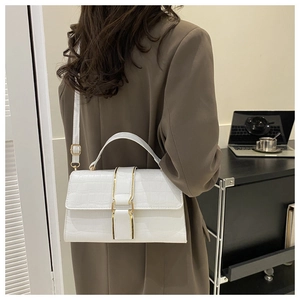 Detail showing white crocodile pattern texture and gold buckle on stylish small square bag