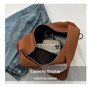 Sac fourre-tout en nylon marron montrant la capacité intérieure pour portable et portefeuille