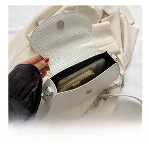 Detail of white crocodile pattern saddle bag showing spacious interior for phone and wallet