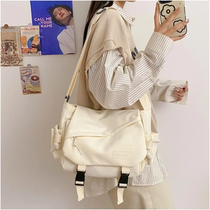 Detail of Harajuku style canvas messenger bag featuring plastic buckles and fashion tag