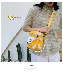 Détail de la sacoche en toile jaune avec un ours en peluche 3D et un patch cupcake