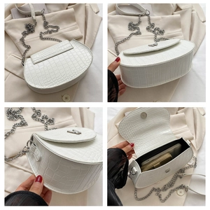 Detail showing the white crocodile pattern saddle bag with a silver butterfly buckle