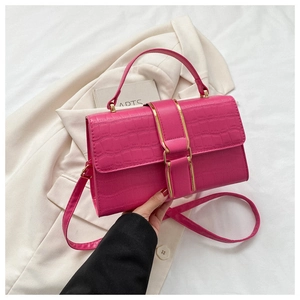 Close-up of fuchsia crocodile pattern leather bag with elegant gold metal clasp