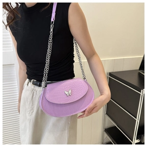 Detail of lavender crocodile texture faux leather bag featuring a silver butterfly clasp