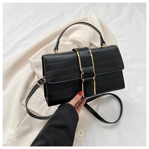 Close-up of black crocodile embossed leather handbag with gold metal clasp detail