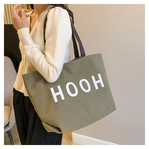 Vue détaillée du grand sac fourre-tout en toile vert armée avec imprimé HOOH et anses brunes