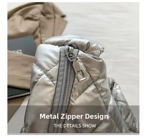 Detailed close-up of the smooth metal hardware zipper on silver quilted tote bag