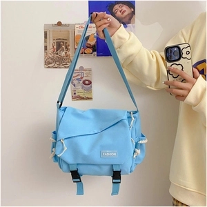 Close-up of light blue messenger bag showing buckle closure and fashion label