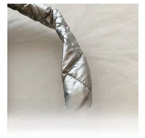 Close-up of quilted silver metallic shoulder strap with soft padding and rhombus stitching