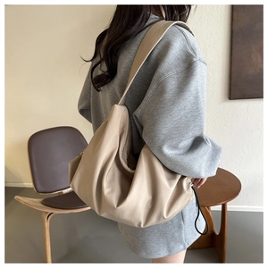 Détail du sac hobo en nylon kaki avec large bandoulière et tirette de fermeture éclair