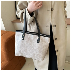 Detail of grey marble texture PU leather tote with black handles and gold rivets