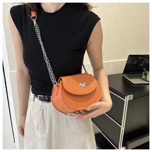 Close-up of the bright orange faux crocodile leather texture and silver butterfly buckle