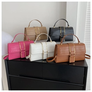 Detail view of five luxury crocodile pattern handbags with elegant gold metal buckles