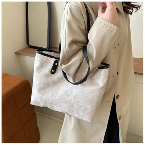 Close-up of grey marble texture tote bag with black leather trim and gold rivet details