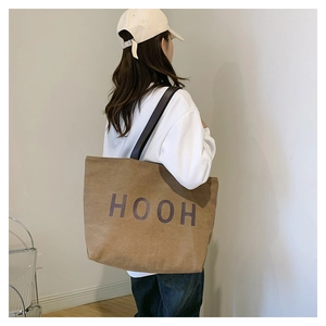 Détail d'un grand sac cabas marron avec lettrage HOOH violet et bandoulières noires