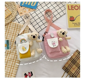 Détail du sac bandoulière en toile avec ours en peluche et broderies de dessins animés