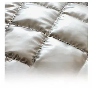 Detailed view of silver metallic quilted fabric with square stitching on casual tote bag
