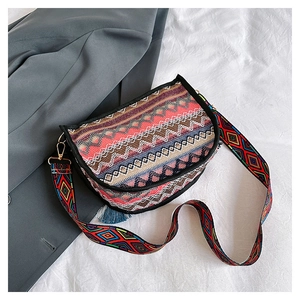Detailed close-up of a bohemian saddle bag with colorful geometric patterns and blue tassel