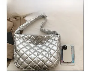 Macro view of silver quilted tote bag with metallic finish and soft down-like texture