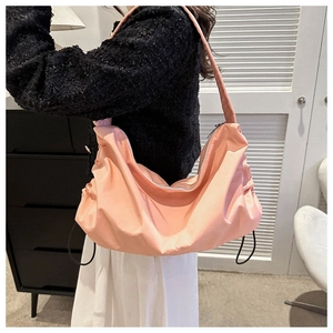 Sac hobo en nylon rose porté par un mannequin avec détails de cordon et fermeture éclair