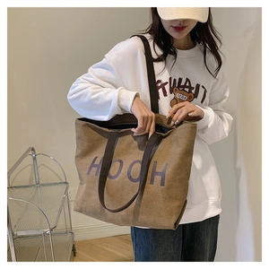 Sac fourre-tout en toile marron avec lettres HOOH mauves porté dans un décor d'intérieur