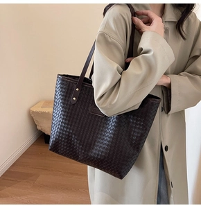 Close-up of brown woven tote bag featuring a checkerboard pattern and fashion label tag
