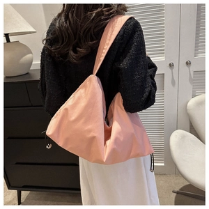 Sac hobo en nylon rose avec cordon de serrage et large bandoulière sur modèle