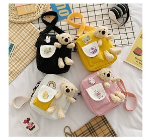 Vue à plat de quatre sacs bandoulière en toile avec ours en peluche 3D et motifs mignons