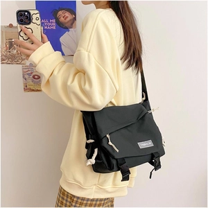 Side view of the black messenger bag showing large capacity and adjustable shoulder strap
