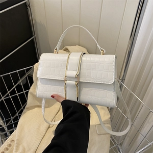 White crocodile embossed leather crossbody bag with gold buckle and top handle