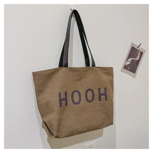 Gros plan sur le sac fourre-tout en toile avec imprimé HOOH et anses en cuir brun