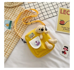 Détail du sac à bandoulière jaune en toile avec ours en peluche 3D et motif cupcake