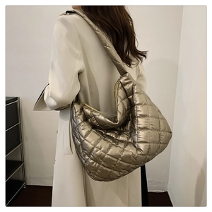 Detail of champagne gold quilted puffer bag showing large capacity and metallic texture