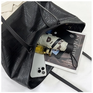 Top view of large black tote bag showing spacious interior with umbrella and tablet