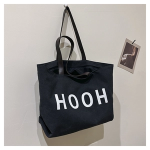 Détail du sac cabas minimaliste en toile noire avec anses brunes et lettrage HOOH blanc